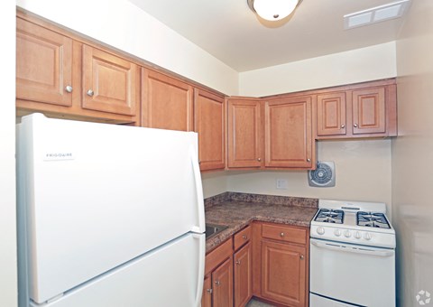 a kitchen with wooden cabinets and white appliances at Willow Gardens Apartments, Teaneck, NJ, 07666